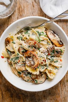 a white bowl filled with pasta and mushrooms