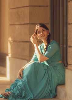 a woman in a blue dress sitting on the steps