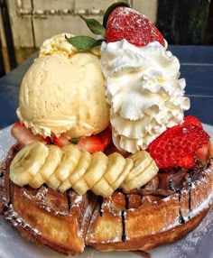 a waffle topped with bananas, strawberries and ice cream