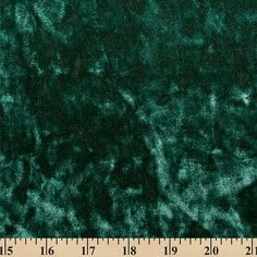 a ruler is next to a dark green velvet material that looks like it has been dyed