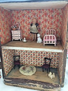 an old doll house with furniture and dolls in it