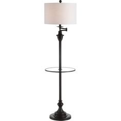 a lamp that is on top of a glass stand with a white shade over it