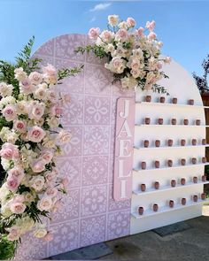 a pink and white flower display with flowers on it's side, next to a sign that says jade