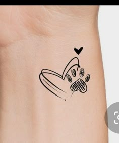 a small tattoo on the wrist of a person with a dog's head and paw