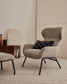 a chair and ottoman in a room with a rug on the floor next to it