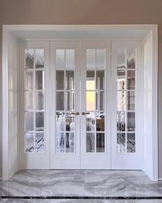 an empty room with glass doors and marble flooring