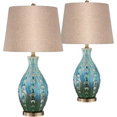 two lamps with shades of blue and green on each lamp are next to each other