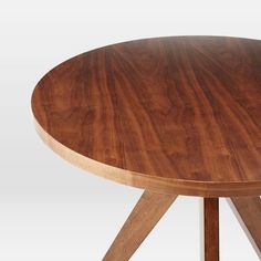 a round wooden table with two crossed legs