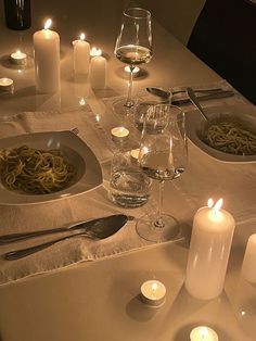 a dinner table with candles and dishes on it