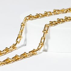 Your go-to accessory for effortless style and modern glamour! This piece is composed of multiple horseshoe shaped 1cm links with small gold balls as clasps, making it an instant standout. Tiffany's sell their solid gold version for $25,000! Our necklace offers the same chic look and with waterproof. tarnish proof, 18K Gold coating for a fraction of the cost but with all the same life-proof durability. All our pieces come with free extenders attached so you can fit the look to your own body and s