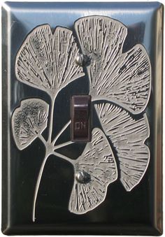 a decorative light switch cover with an image of a flower on the front and side