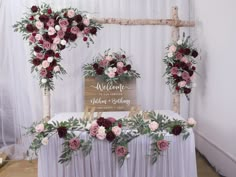 an arrangement of flowers and greenery decorates the head table at a wedding reception