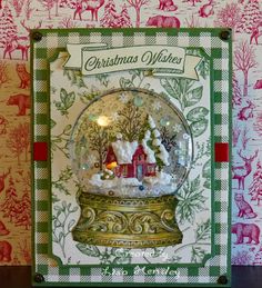 a christmas card with a snow globe in the shape of a house and reindeers