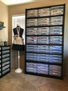 a display case filled with plastic drawers next to a mannequin