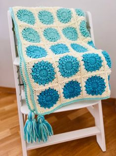 a crocheted blanket sitting on top of a white chair