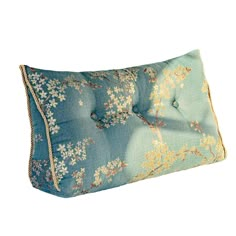 a blue and gold pillow with flowers on it