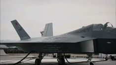 a fighter jet sitting on top of an airport tarmac