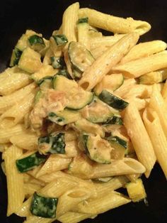 pasta with zucchini and spinach on a black plate