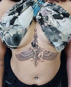 a woman's stomach with an egyptian bird tattoo on her belly and the top part of her chest