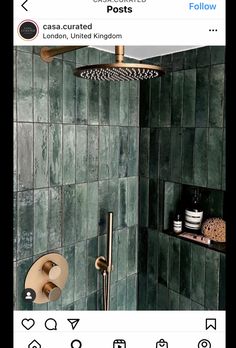 a green tiled shower with gold faucet and soap dispenser next to it