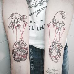 two people with tattoos on their arms holding hands and heart shaped balloons attached to each other