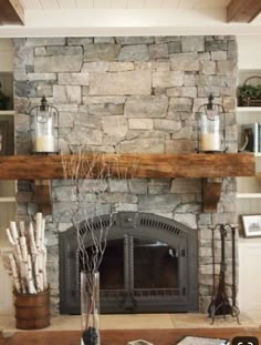 a living room with a fire place and stone fireplace mantel in front of it