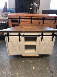 a kitchen island with sliding doors on the front and side, sitting in a garage