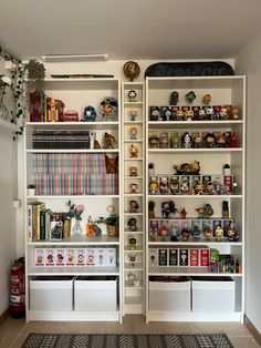 two white shelves filled with toys and books on top of each other in a room