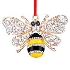 a yellow and black bee ornament hanging from a red ribbon