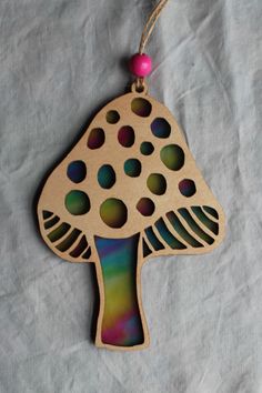 an ornament shaped like a mushroom is hanging on a piece of paper with beads