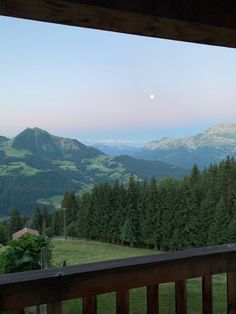 a view of mountains and trees from a deck