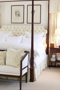 a bed with white linens and pillows in a bedroom next to two lamps on either side of the bed