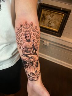 a person with a buddha tattoo on their arm