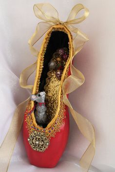 a red shoe with gold sequins and a mouse in it