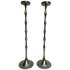 two metal candlesticks sitting on top of each other