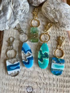 five different pieces of glass sitting on top of a table next to rocks and coins