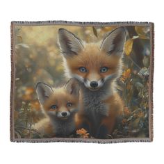 two little foxes are sitting in the grass with their eyes open and one is looking at the camera