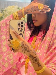 a woman with henna on holding up her cell phone