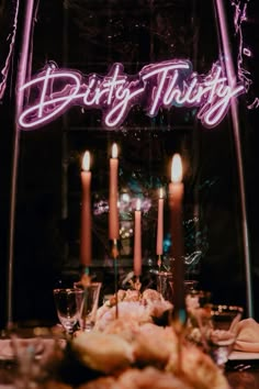 a lighted sign that says dirtyy thrift next to some food on a table