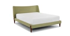 an upholstered bed with white sheets and green headboard, on a white background