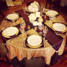 the table is set with white and gold plates