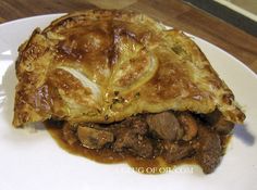 a piece of meat and vegetable pie on a white plate