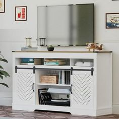 a white entertainment center with a flat screen tv mounted on it's sideboard