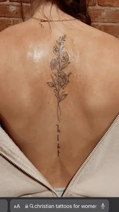 the back of a woman's neck with flowers on it and words written in cursive writing