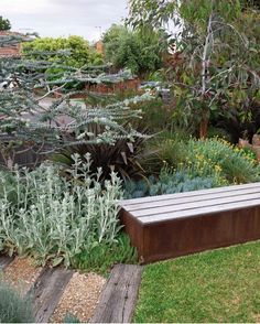 a wooden bench sitting in the middle of a garden