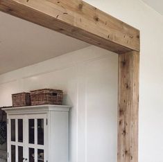 a white cabinet with baskets on top of it