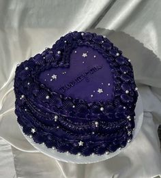 a purple heart shaped cake with stars on it