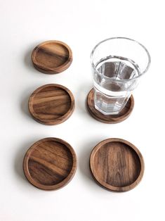 four wooden coasters with water in the middle and one empty glass on each side