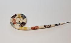 a white snake with multicolored leaves on it's back end and tail