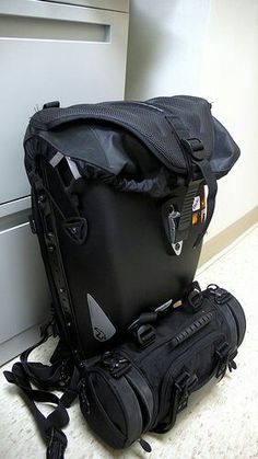 a black bag sitting on the floor next to a suitcase